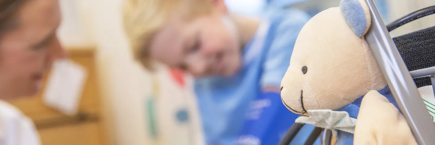 Barn på sykehus med bamse i front.