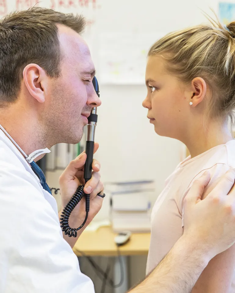 Lege undersøker øynene til et barn.