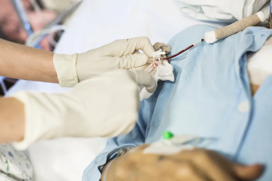 En person i hvit laboratoriefrakk og en pasient.