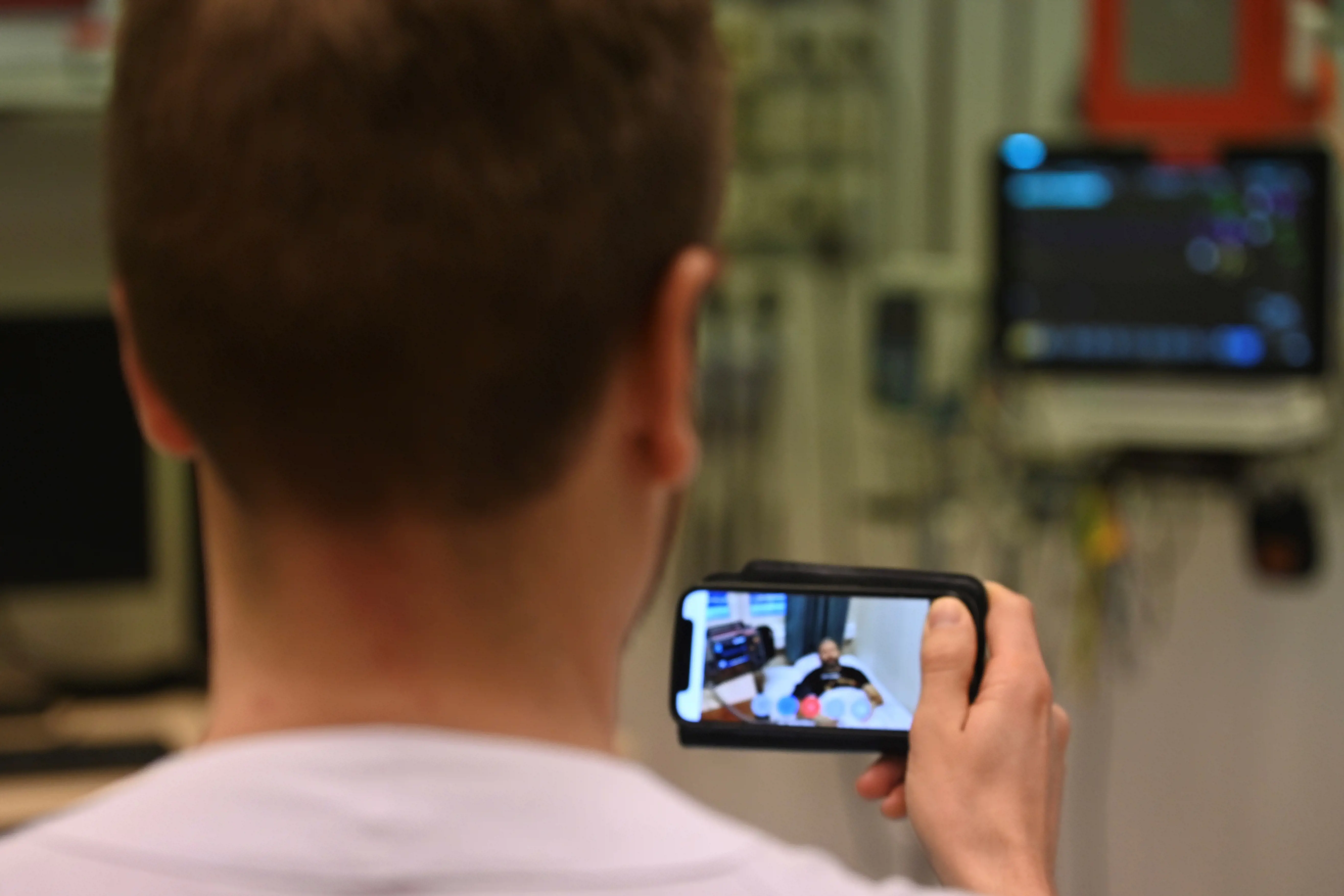 Lege observerer pasient via hodekamera med videooverføring.