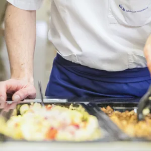 Ansatt i kantina ved salatdisken, illustrasjonsbilde.