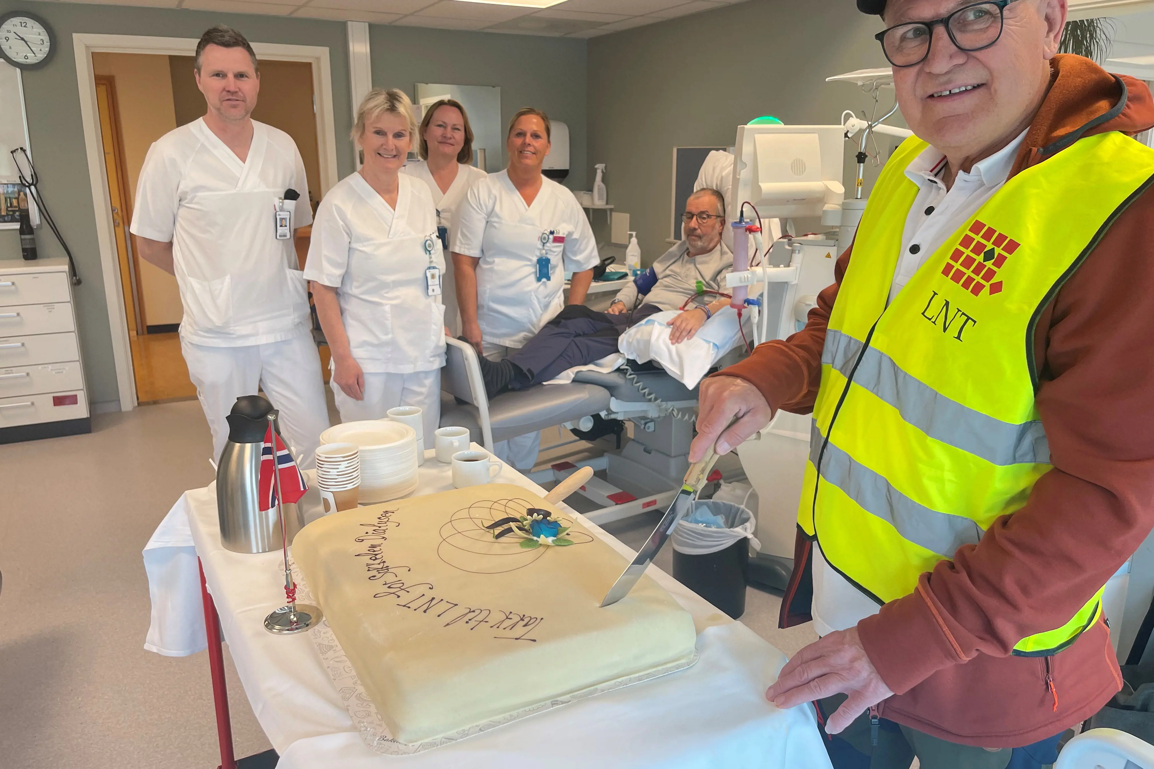 Fylkesleder i LNT skjærer kake til ansatte på dialyseavdelingen på Lillehammer